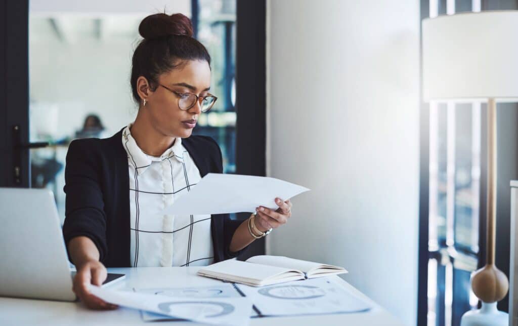 Attorney carefully reviewing case documents at a desk in a modern law office