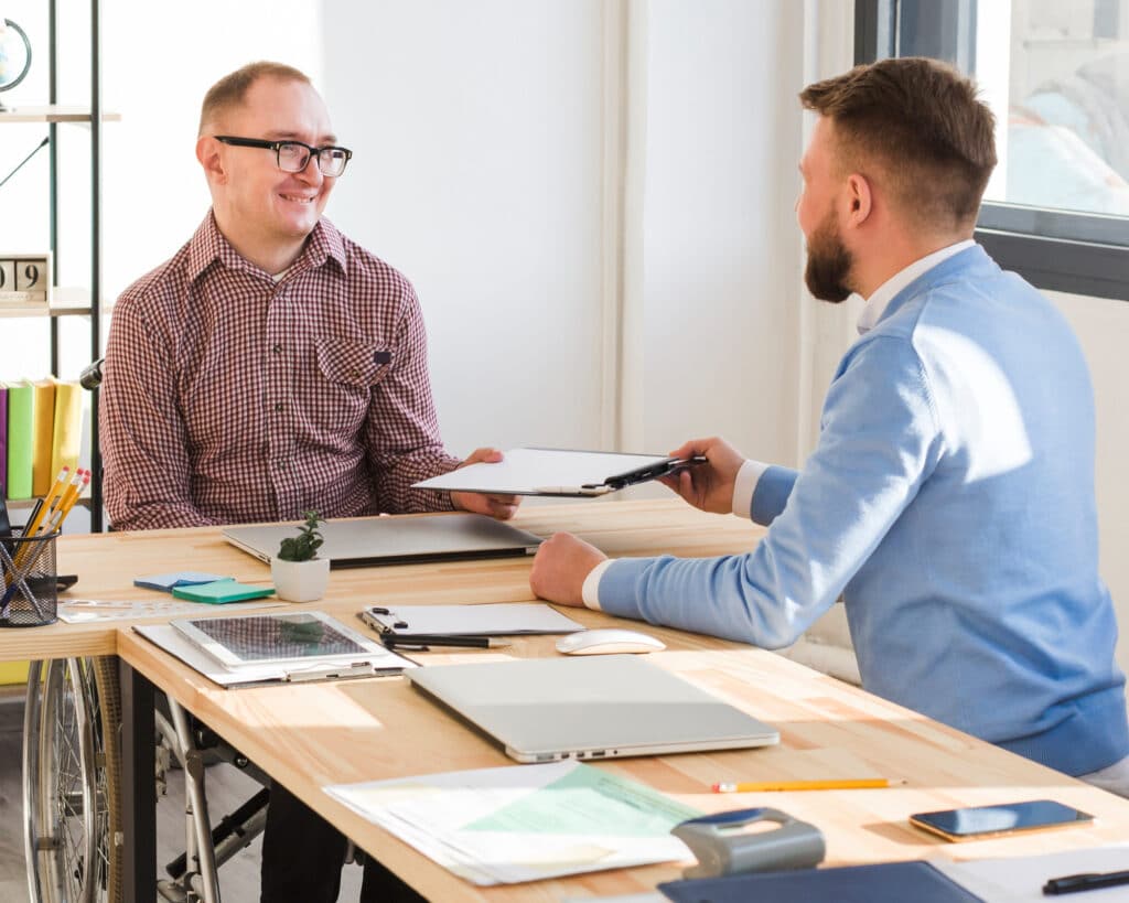Employer and worker reviewing professional documents in an office